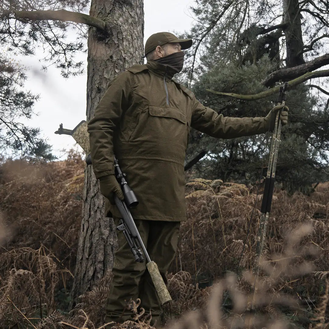 Armed person in camouflage wearing Seeland Avail Smock in a forest setting