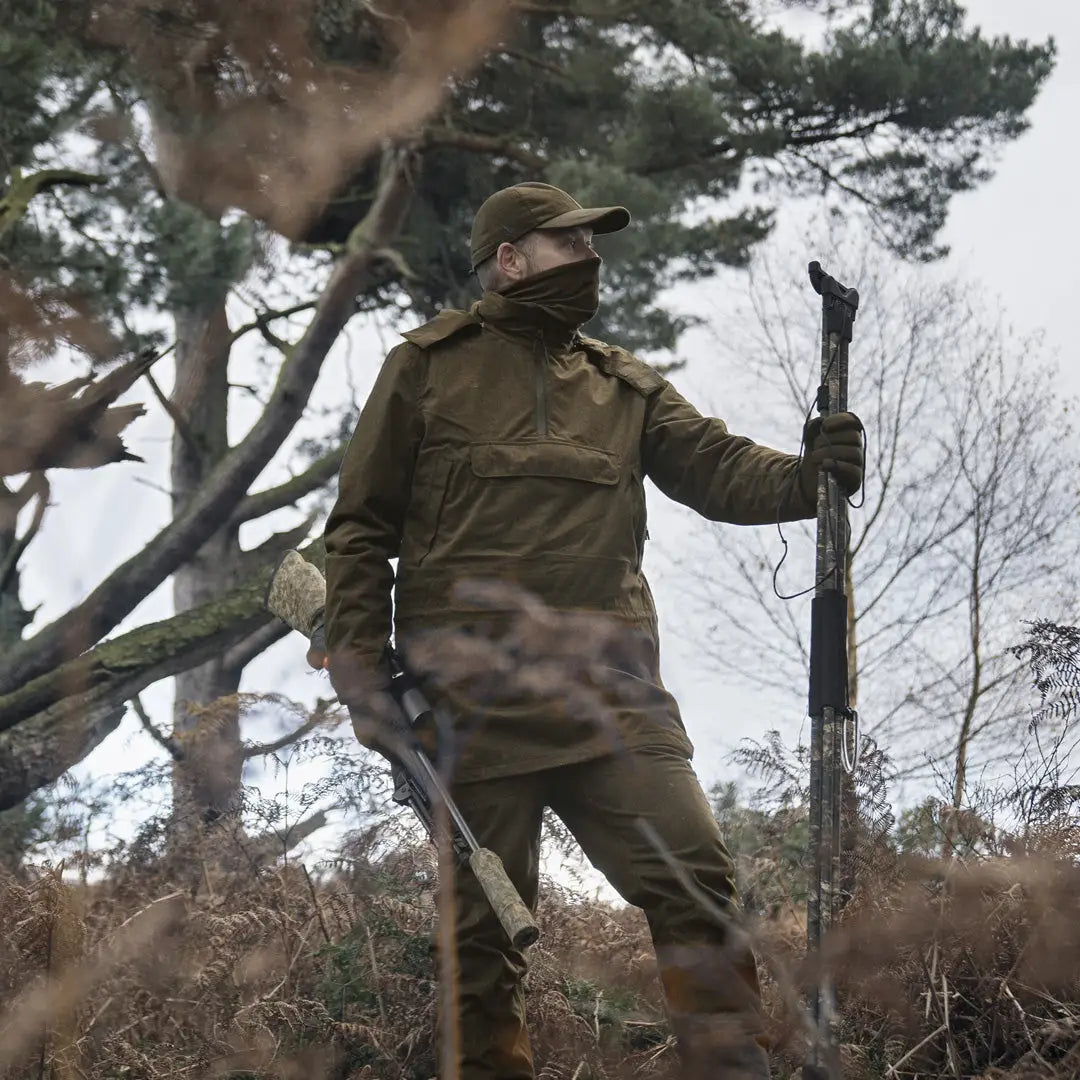 Hunter in camouflage holding a rifle wearing the Seeland Avail Smock for no-frills hunting