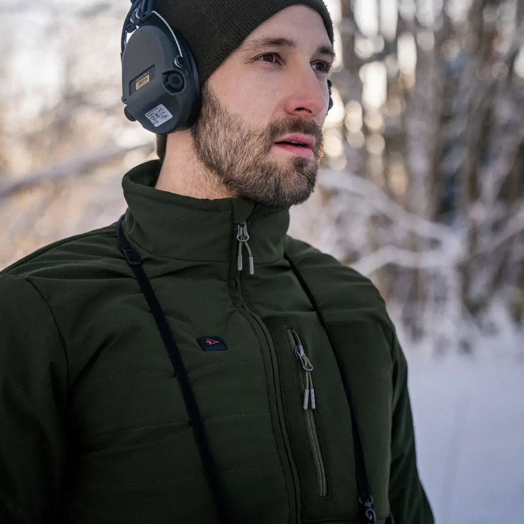 Bearded guy in a dark green Seeland Celsius Heat Jacket and black beanie with headphones