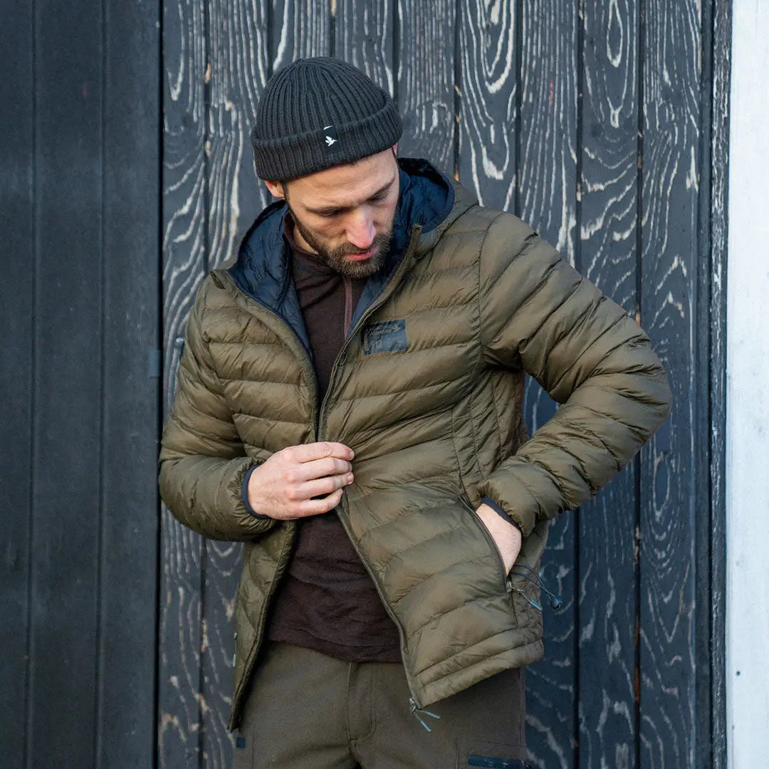 Man in a puffy olive-green Seeland Fahrenheit Jacket and black knit hat