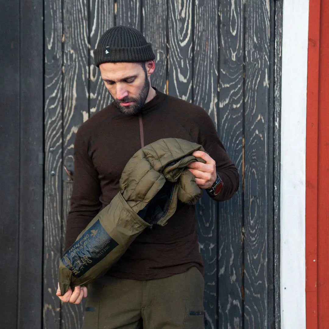 Bearded man in a cap checks out the Seeland Fahrenheit Jacket in olive green