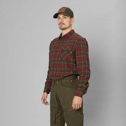 Man in a plaid flannel shirt, cap, and olive pants showcasing Seeland Glen Flannel