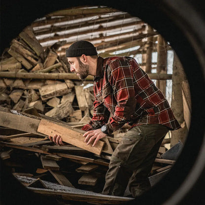 Man in a plaid shirt and beanie using a Seeland Glen Flannel Shirt in a rustic setting