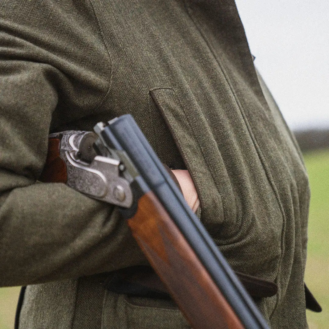 Shotgun with engraved receiver against Seeland Hillside Harriet Jacket in green