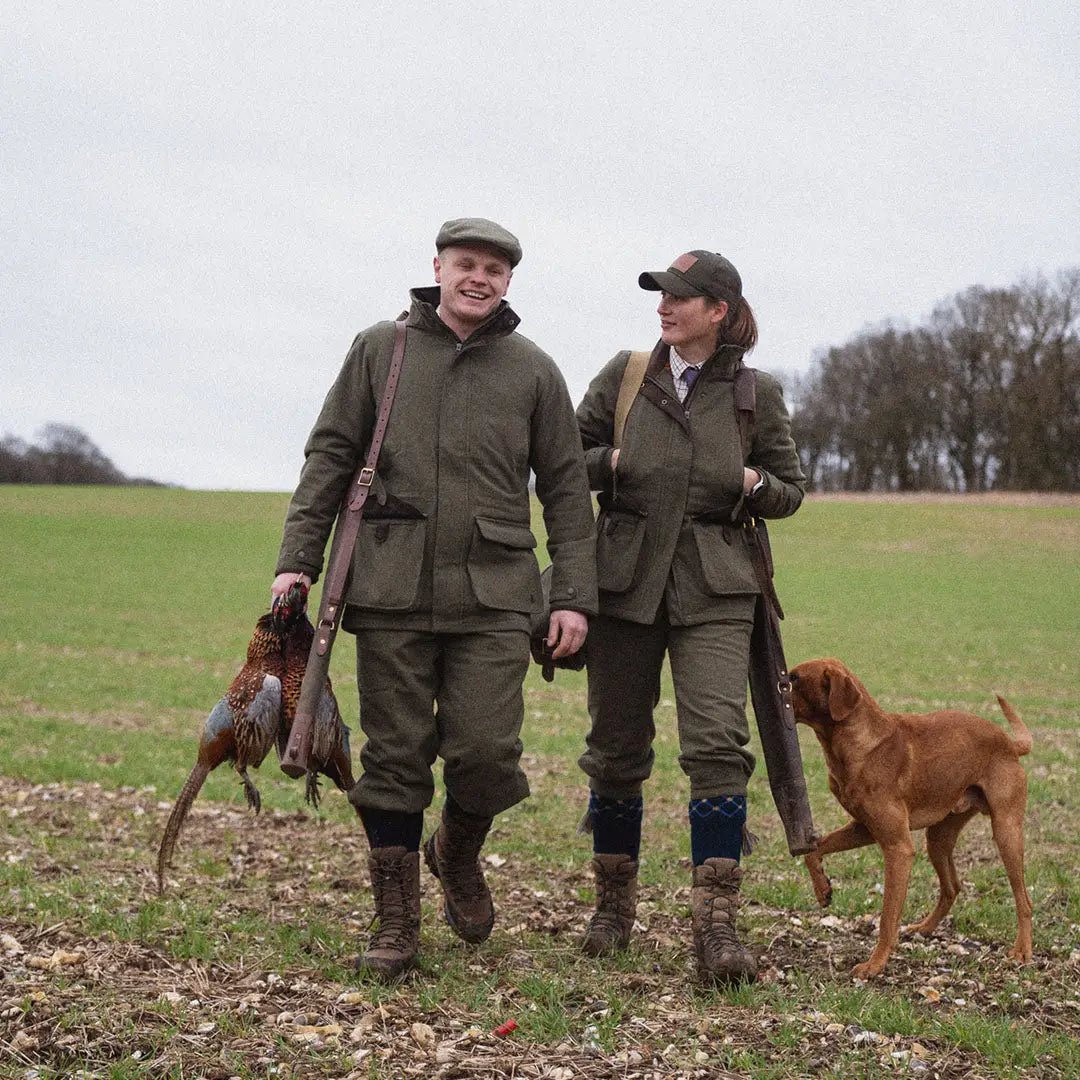 Two hunters in Seeland Hillside Jacket walking with a dog and a pheasant