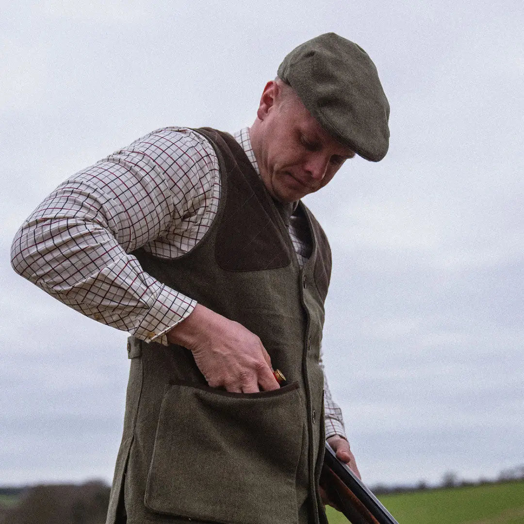 Man in traditional hunting gear with a shotgun wearing Seeland Hillside Waistcoat