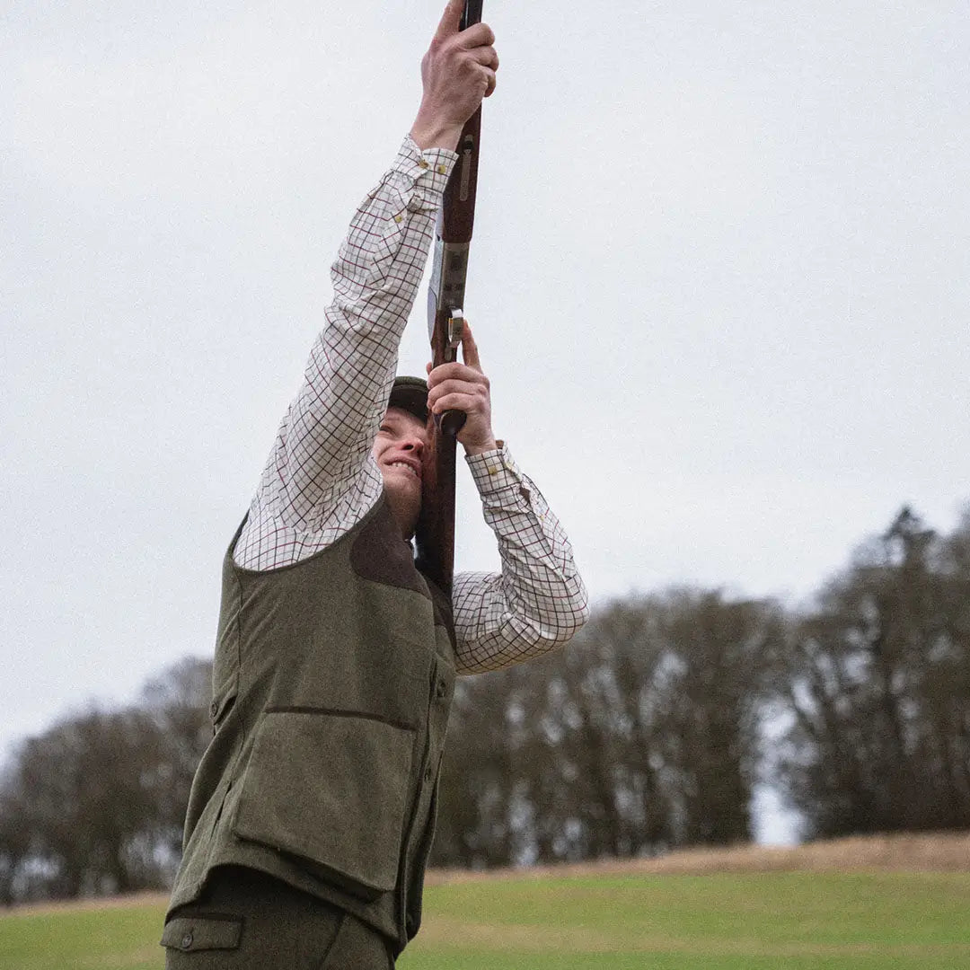 Man in outdoor gear aiming shotgun wearing Seeland Hillside Waistcoat