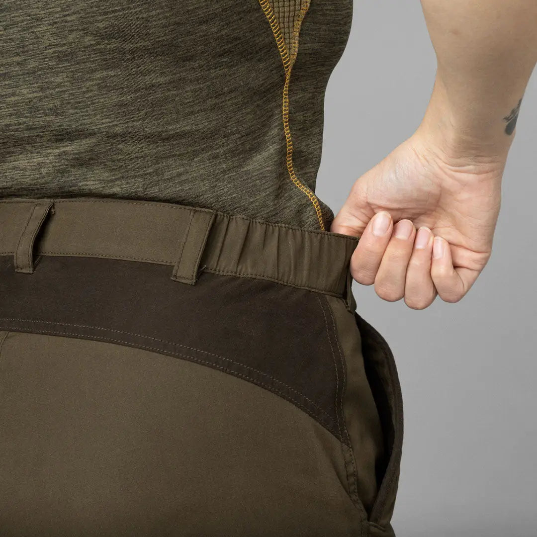 Hand gripping the waistband of Seeland Key-Point Kora Ladies Trousers in action