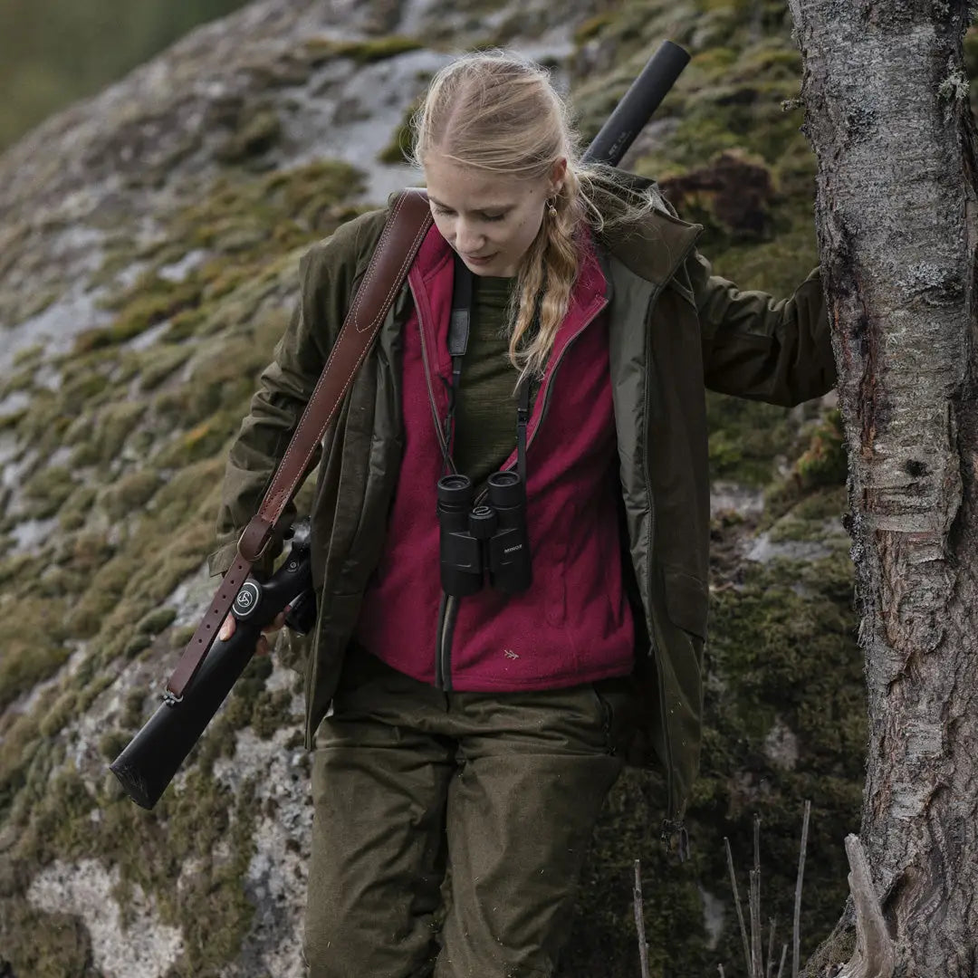 Person in Seeland Ladies Woodcock Fleece Waistcoat carrying a rifle in nature