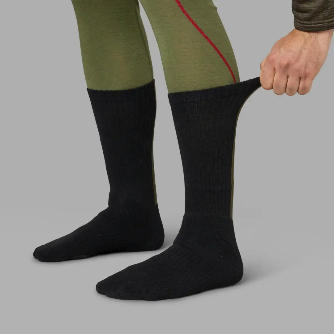 Black knee-high Moor socks worn with olive green pants from Seeland’s 3-pack collection