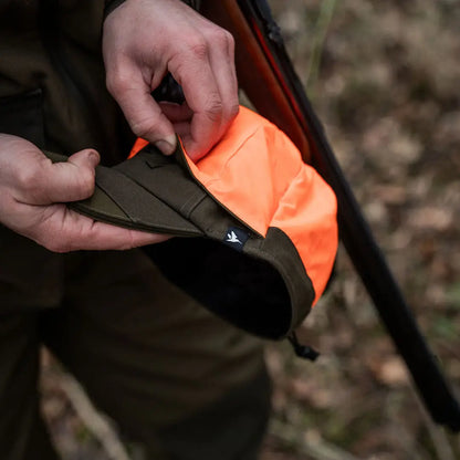 Bright orange safety vest clips onto dark clothing with Seeland Trax Cap style