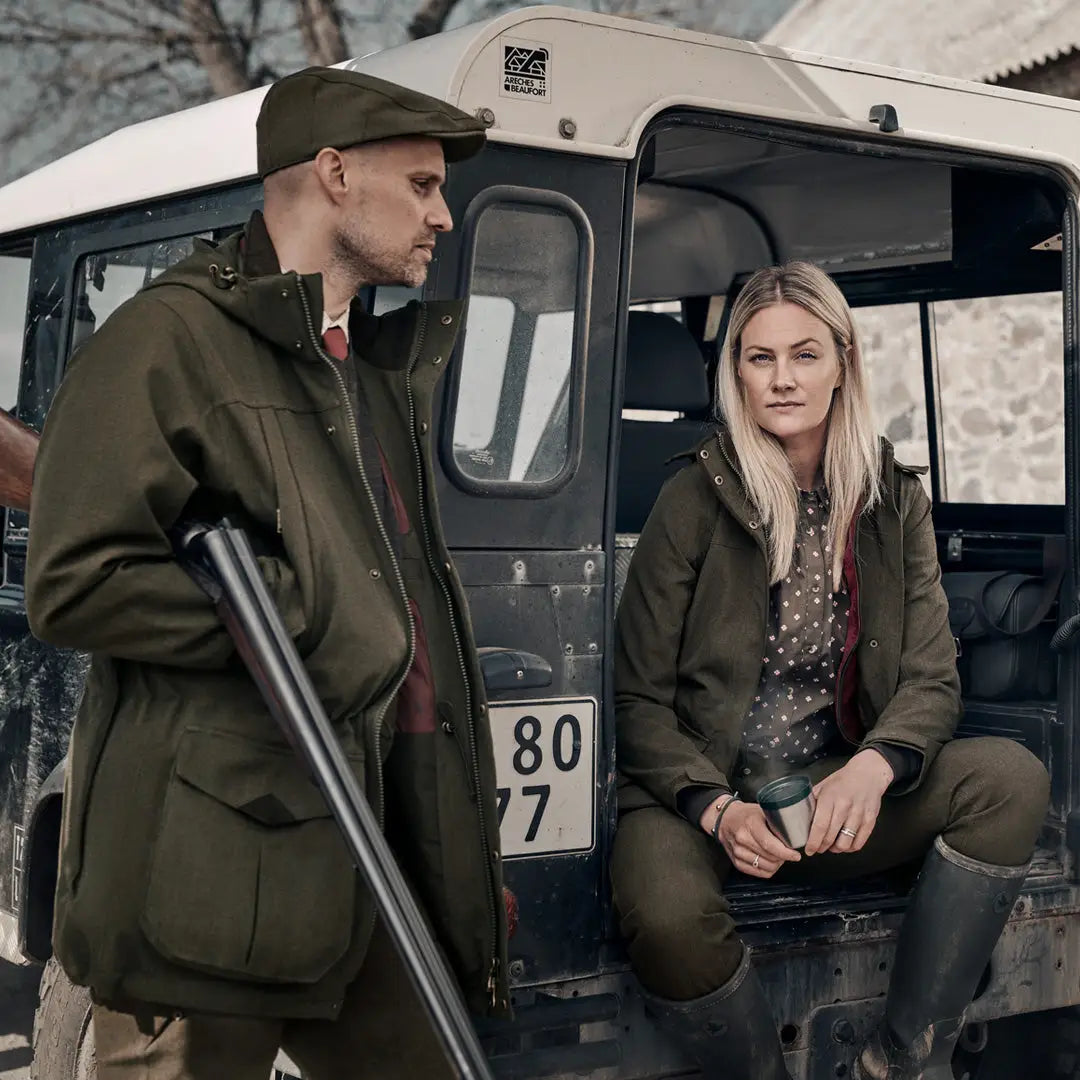 Military-style vehicle with two people by open door in Seeland Woodcock Advanced Jacket