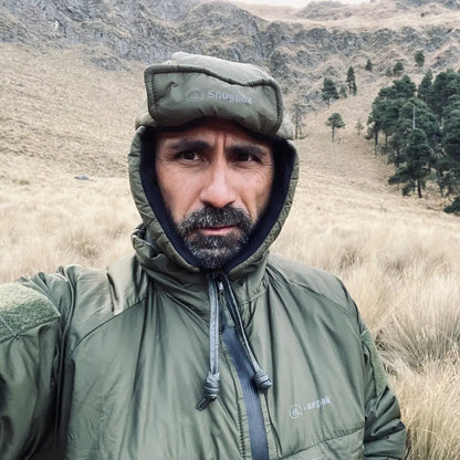 Bearded guy in a green Snugpak Snugnut jacket enjoying outdoor walking in nature