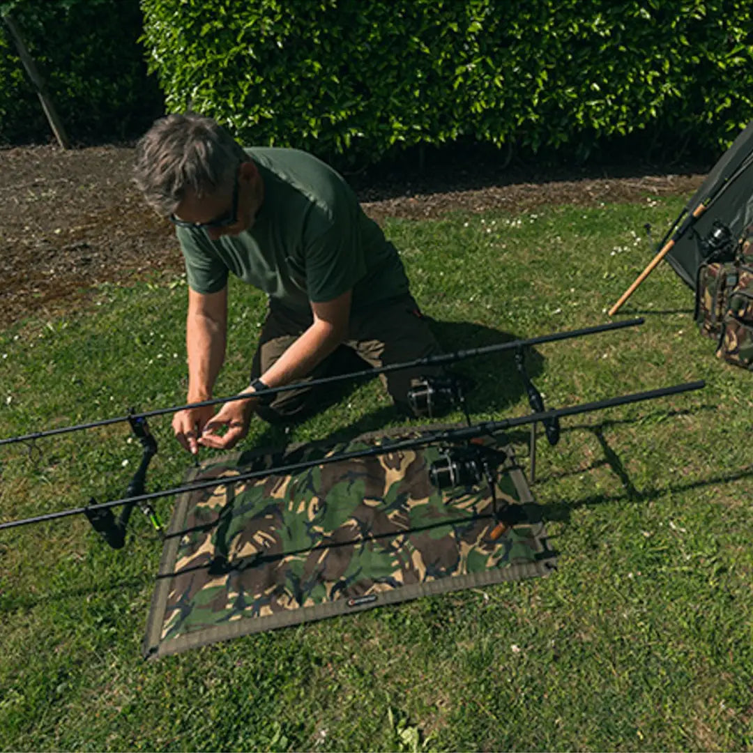 Fishing rod holder on grass showcasing Speero Bivvy Mat with multiple rods attached