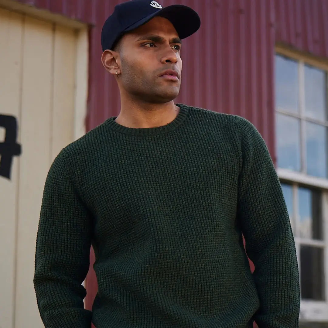 Man in a dark green sweater and navy blue cap showcasing Swanndri Fistral Waffle Knit