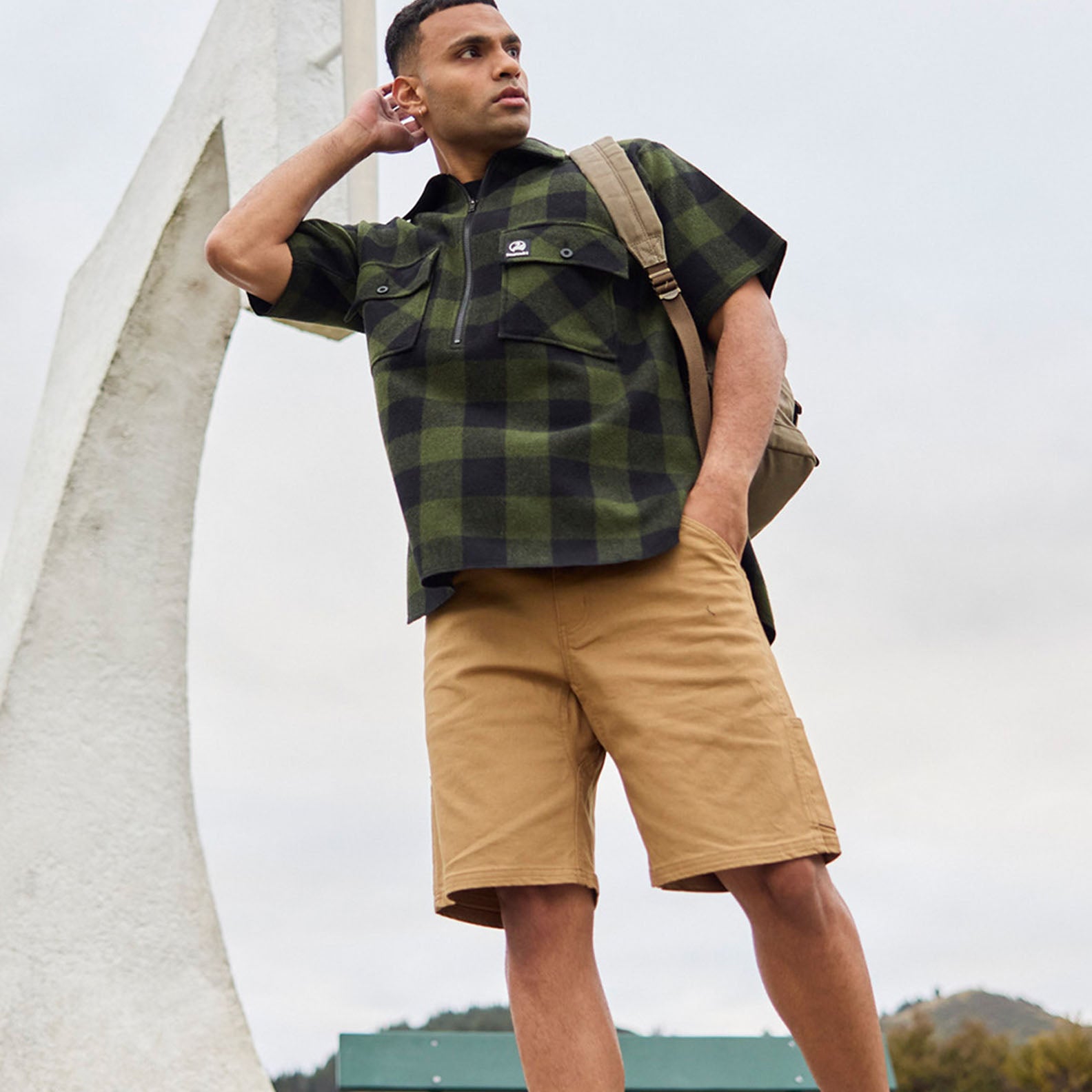 Man in plaid shirt and khaki shorts showcasing Swanndri Glenbrook V3 work shorts for outdoors