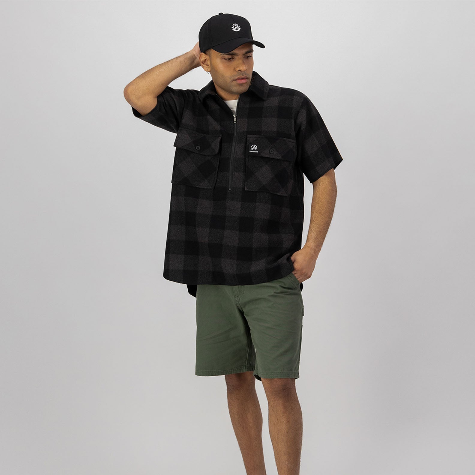 Man in plaid shirt and shorts wearing Swanndri Henderson Half Zip Jacket with 260gsm lightweight wool