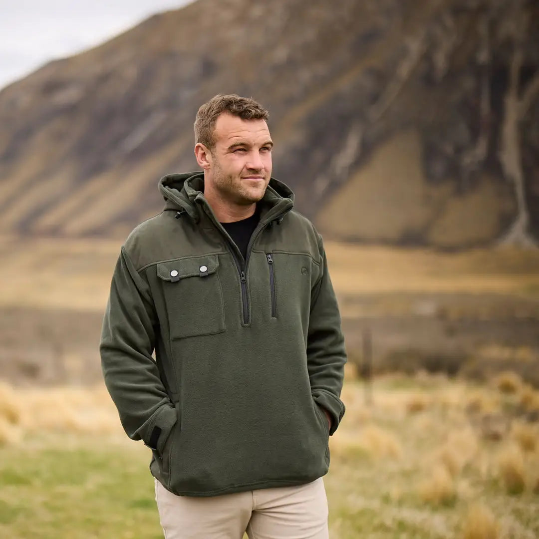 Man in green Swanndri High Rock hoodie with domed flap pocket in outdoor setting