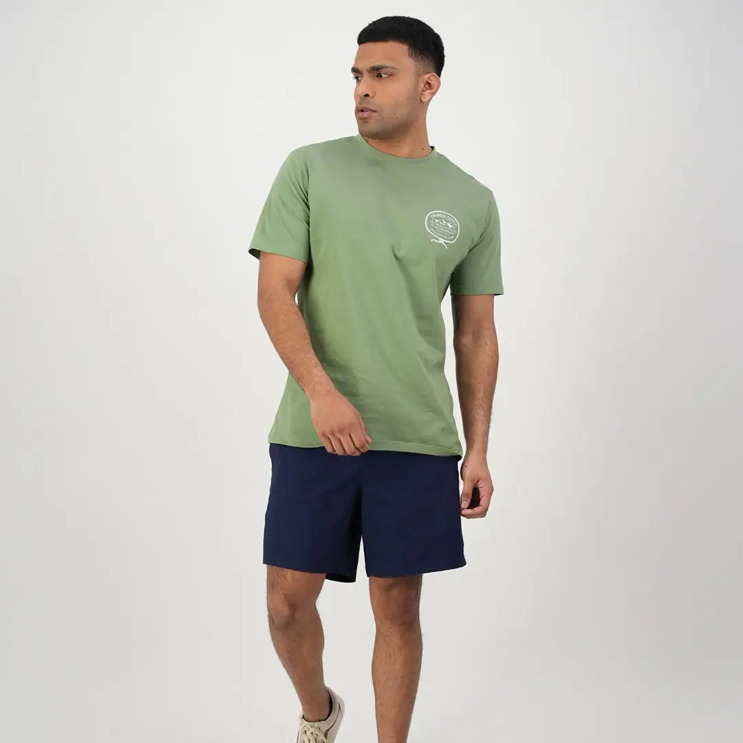 Man in a green t-shirt and navy shorts, perfect for country clothing and outdoors adventures