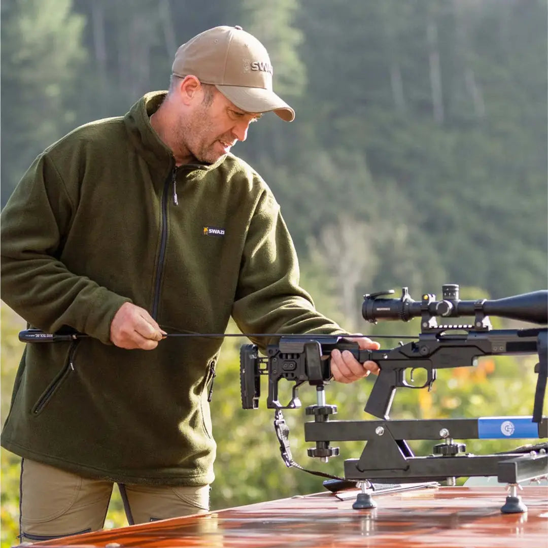 Sniper rifle on tripod with Swazi Doughroaster Fleece for comfy outdoor adventures