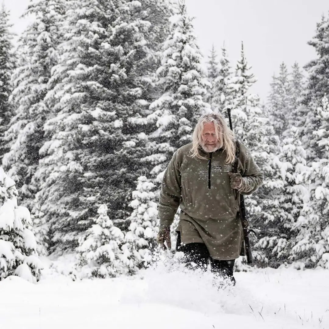 Person trudging through deep snow wearing Swazi’s legendary 350gsm polar fleece smock