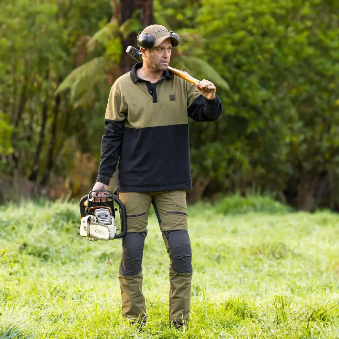 Man in outdoor work gear with chainsaw and axe wearing a Swazi Rugger Jersey