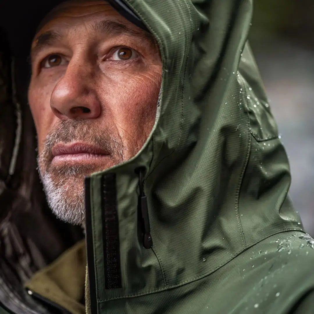 Close-up of a middle-aged man in a green Swazi Tahr Ultralight Jacket featuring 20k waterproof