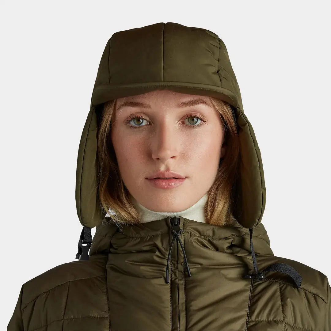 Olive green Tilley Arctic Aviator Hat with ear flaps worn by a stylish person