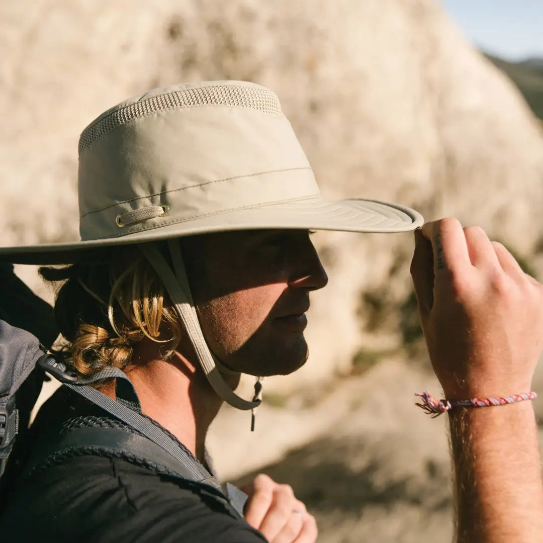 Beige wide-brimmed Tilley LTM6 Airflo Hat worn outdoors for sun protection and style