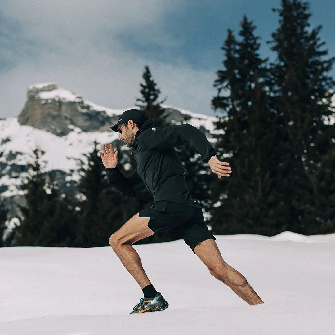 Man running through snow in Venture Ultralight Performance running jacket for winter workouts