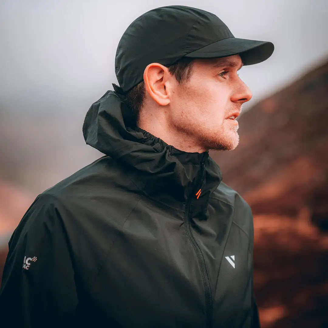 Profile view of a person in a black cap and jacket enjoying the outdoors wearing country clothing