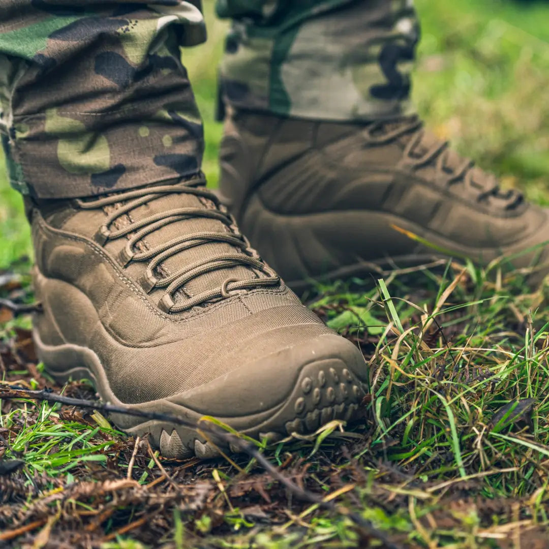 Rugged brown Viper Venom Boots resting on lush mossy ground for outdoor adventures